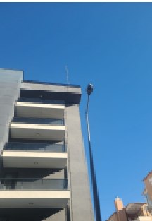 Çok katlı binanın çatısındaki paratoner yakalama ucu ve direği, aşağıdan görünüm.