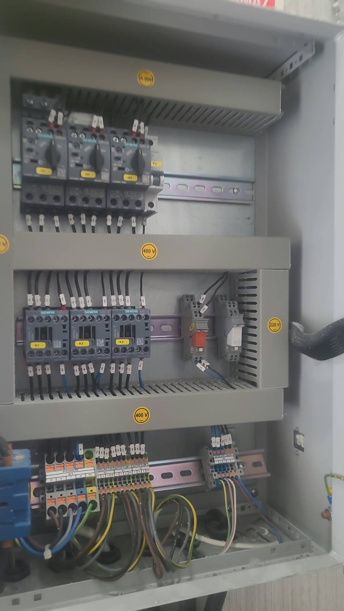 Motor koruma şalterleri, kontaktörler ve terminal bloklarından oluşan bir kumanda panosu iç görünümü.