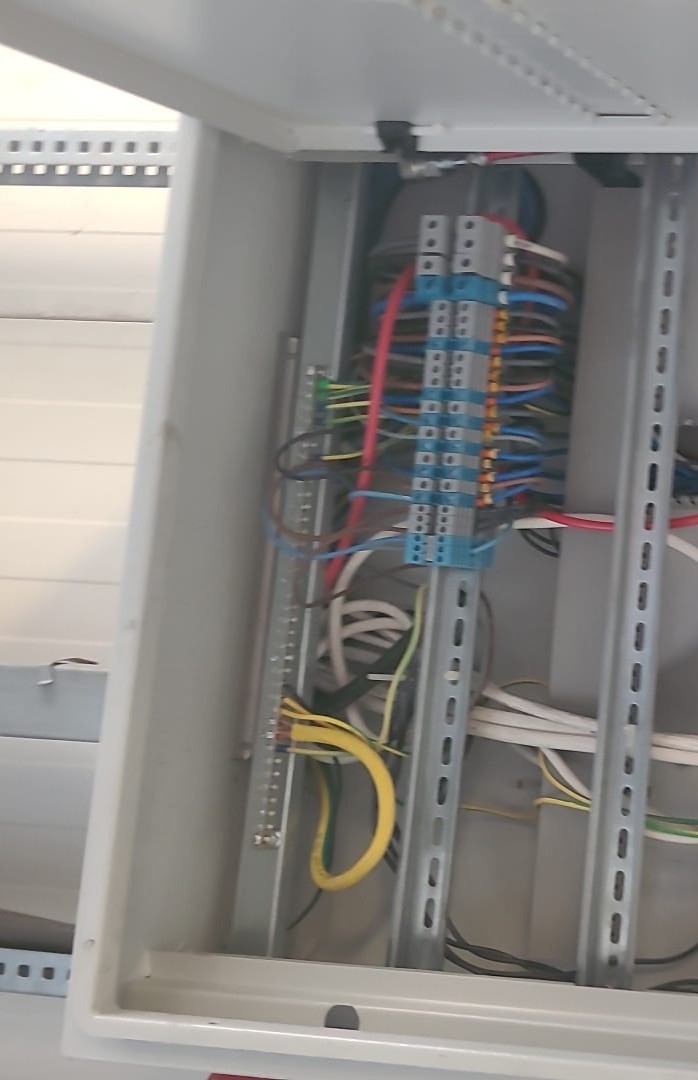 Dağıtım panosu içinde eşpotansiyel topraklama barası; baraya bağlanmış sarı-yeşil koruma iletkenleri ve yanında klemens sıraları.